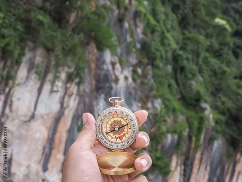 Close up of compass in woman hand with nature as background. The concept of world tourism day, Searching the right directions and Travel