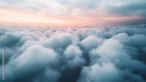 A soft, billowing mass of clouds stretches across the sky at dawn, with a pinkish hue painting the scene in delicate colors, creating an ethereal and dreamy atmosphere.