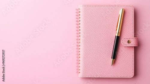 A pink notebook with a pen, ideal for note-taking and organization.