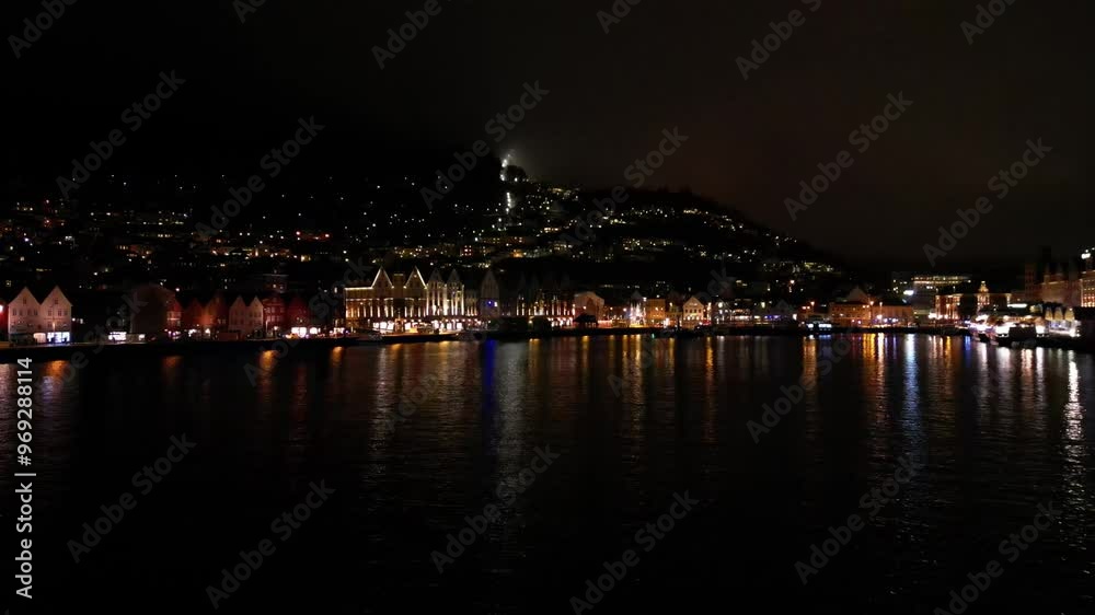 Drone flying on the riverfront to reveal the illuminated city center at night in Bergen, Norway Drone flying on the riverfront to reveal the illuminated city center at night in Bergen, Norway