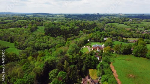 Drone flying over the Wadhurst Town's green landscape on a sunny day with cloudy sky in England photo