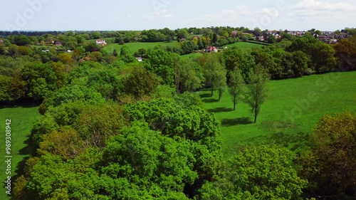 Drone flying over the Wadhurst Town's green landscape on a sunny day with cloudy sky in England photo