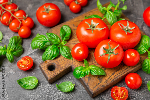 Fresh cherry tomatoes and fresh green basil on a textured background. Tomato sauce. Vegan. Ingredients for salad. Organic food. Place for text. Copy space.