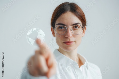 Confident woman with glasses points towards a virtual globe hologram, representing futuristic technology, global communication, and innovation. photo