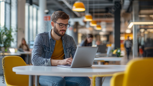 A professional setting up their laptop in a hot-desking environment within an agile office