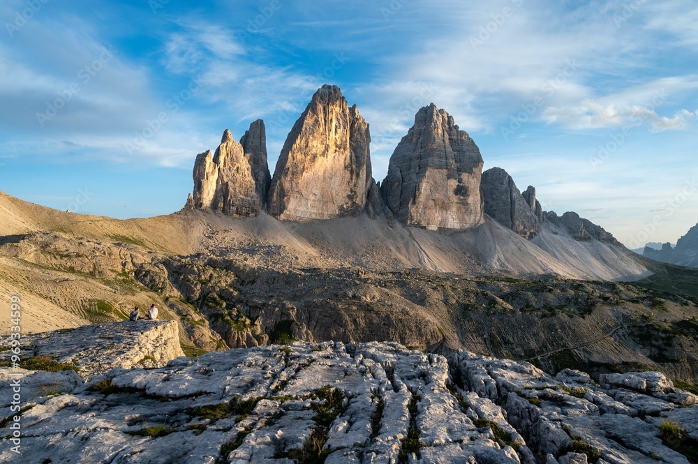 Obraz premium Scenic view of Tre Cime di Lavaredo with two people sitting on rocks