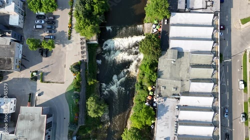 river streaming between trees and buildings on a sunny day in Elora Gorge Conservation Area, Ontario photo