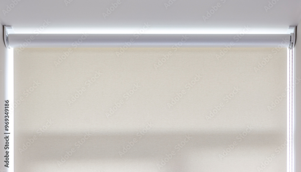 Roller blind chain mechanism close-up. Roller shade in a neutral color on the window provides privacy. Roller blind chain mechanism close-up. Roller shade in a neutral color on the window provides privacy.