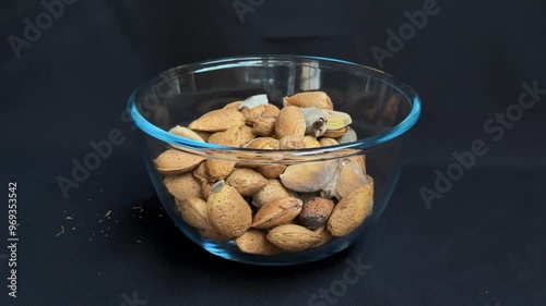 Almonds are poured into a glass bowl