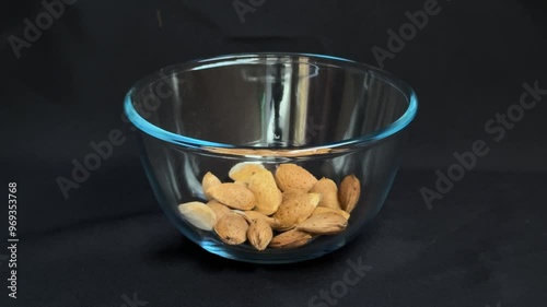 Almonds are poured into a glass bowl