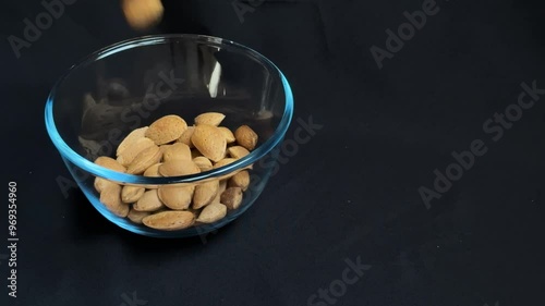 Almonds are poured into a glass bowl