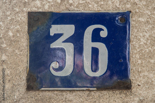 Weathered enameled plate of street address with number 36 photo