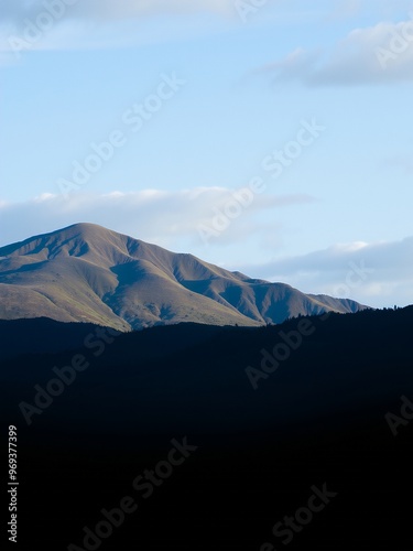 A majestic mountain range silhouetted against a clear blue sky.