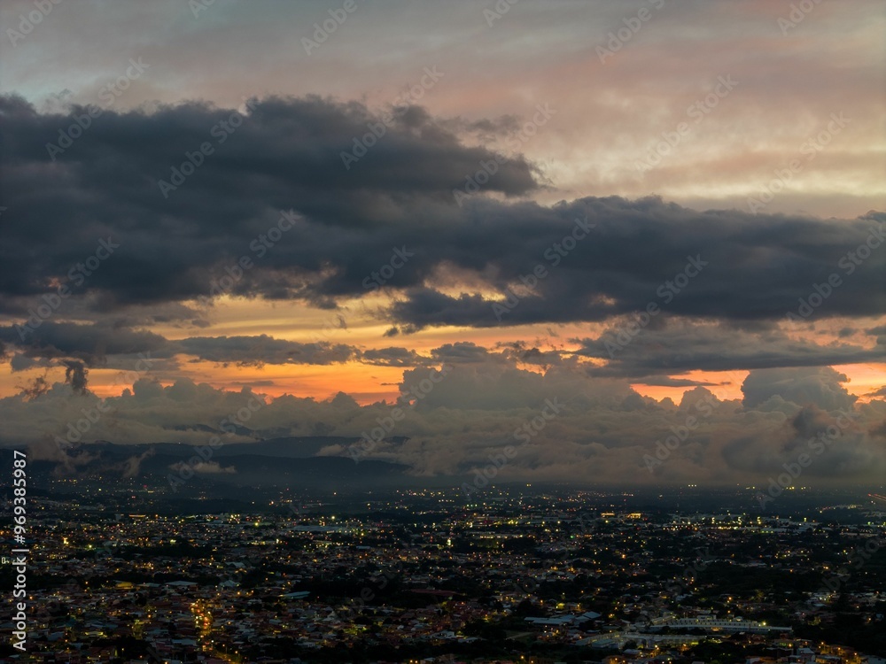 Panoramic view of a cityscape at dusk with dramatic clouds and a colorful sunset sky Panoramic view of a cityscape at dusk with dramatic clouds and a colorful sunset sky