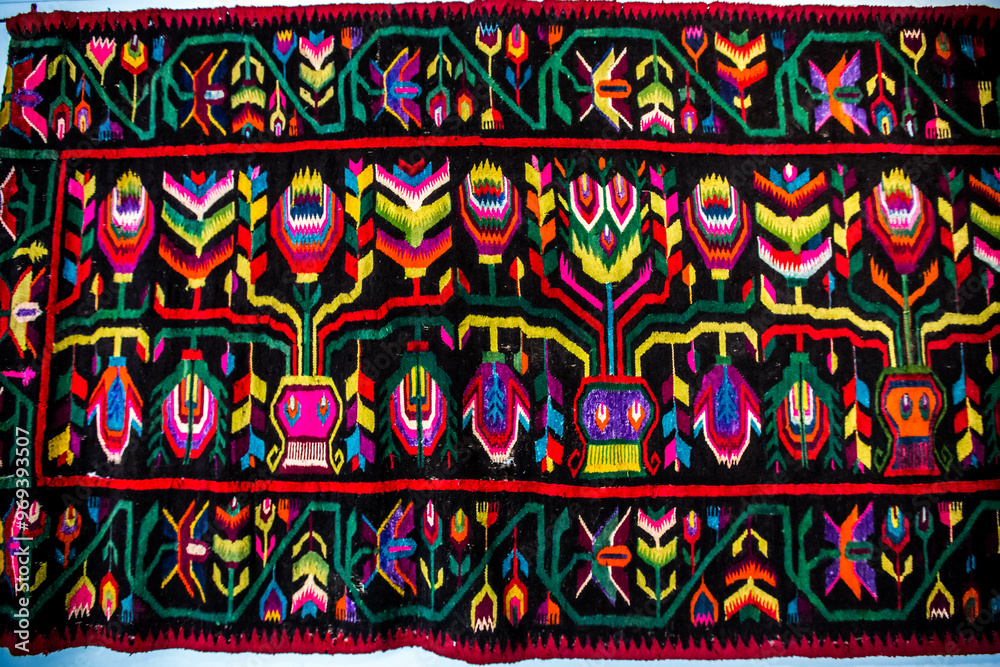 Ornament of traditional Ukrainian multicolored colorful rug. Hutsul ethnic woven smooth hand-woven wool rug with geometric ornaments background and texture. Detail of authentic local motif carpet.