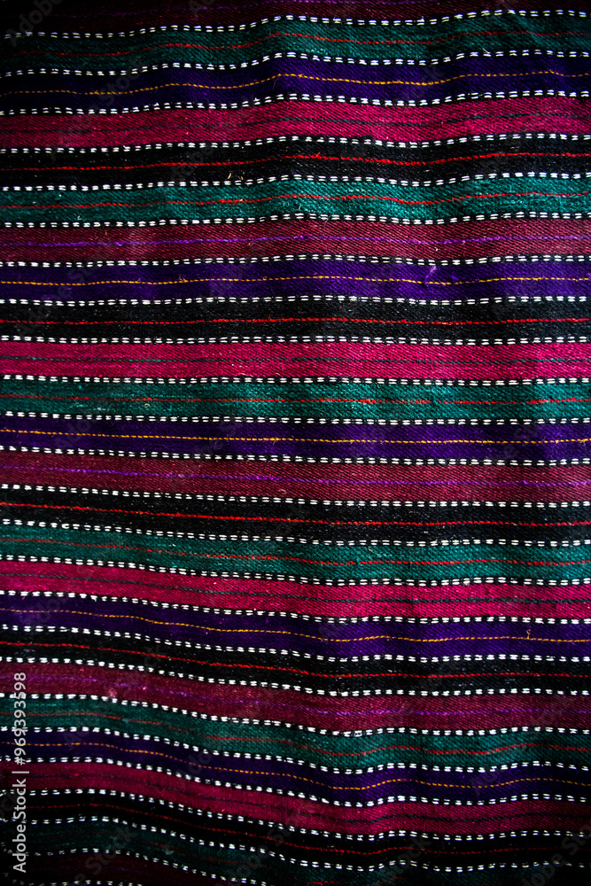 Ornament of traditional Ukrainian multicolored colorful rug. Hutsul ethnic woven smooth hand-woven wool rug with geometric ornaments background and texture. Detail of authentic local motif carpet.