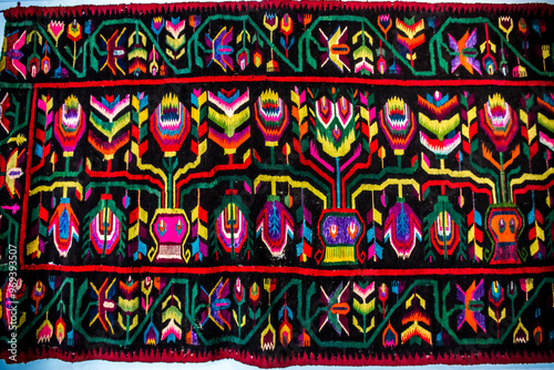 Obraz na płótnie Ornament of traditional Ukrainian multicolored colorful rug. Hutsul ethnic woven smooth hand-woven wool rug with geometric ornaments background and texture. Detail of authentic local motif carpet. w salonie