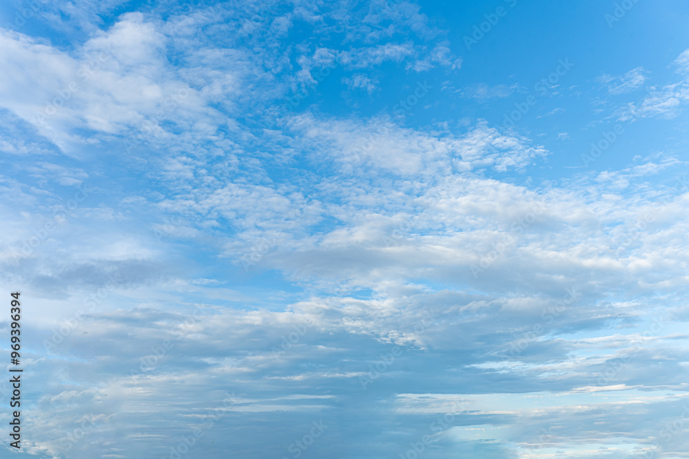 Fluffy white clouds drift across a clear blue sky, painting a breathtaking cloudscape Fluffy white clouds drift across a clear blue sky, painting a breathtaking cloudscape