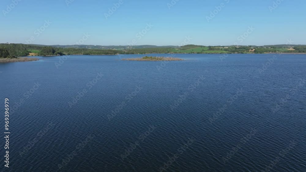 blue body of water in Encoro de Vilagud Reservoir, on a sunny day with blue sky in La Coruna, Spain blue body of water in Encoro de Vilagud Reservoir, on a sunny day with blue sky in La Coruna, Spain