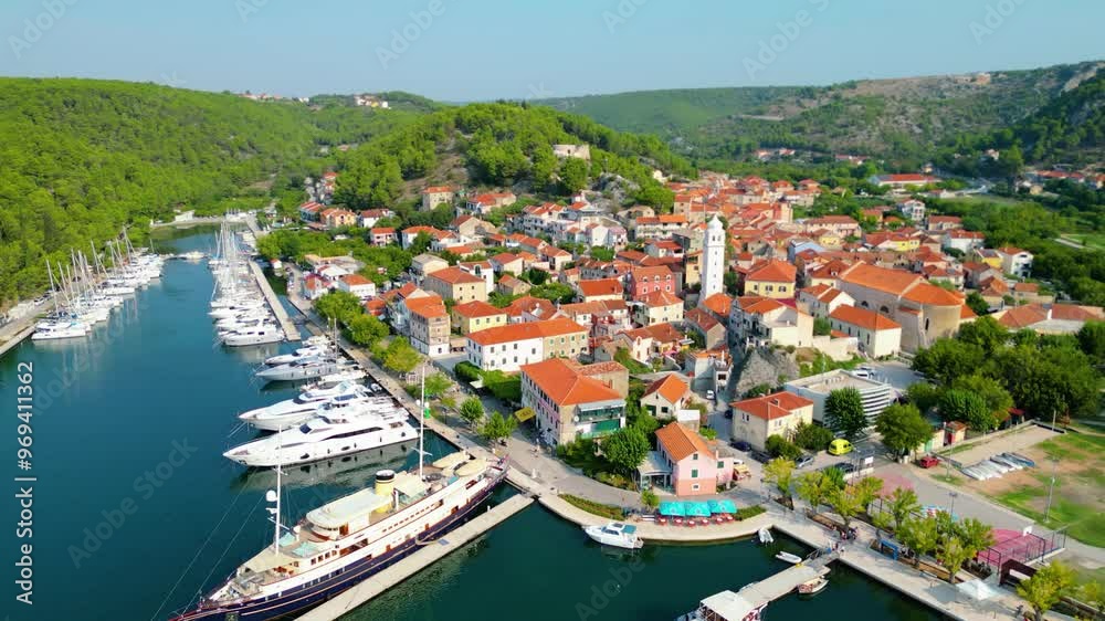 An aerial view of Skradin, a charming town near Krka National Park in Croatia. Nestled along the Krka River, the town features a picturesque marina filled with yachts and boats. An aerial view of Skradin, a charming town near Krka National Park in Croatia. Nestled along the Krka River, the town features a picturesque marina filled with yachts and boats.