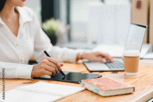 A person using tablet and laptop in modern workspace, showcasing productivity and creativity