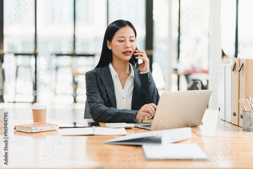 Efficient businesswoman on phone, working at modern office desk