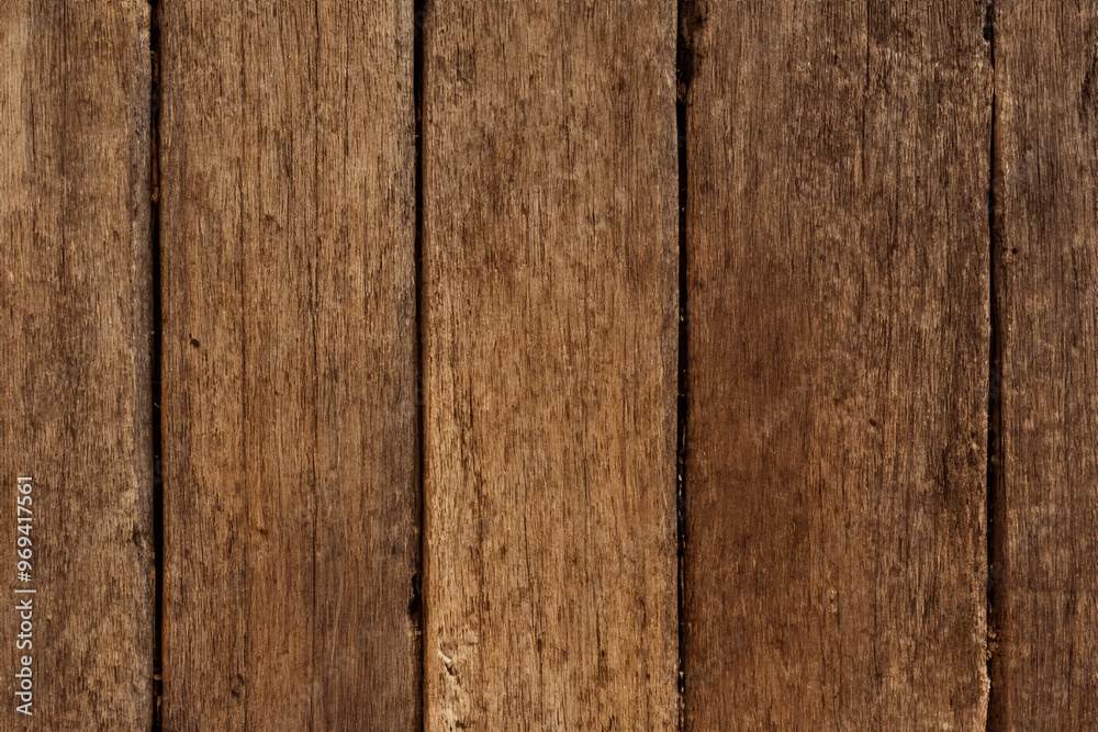 Close-up of a weathered brown wood plank with a natural grain pattern. Close-up of a weathered brown wood plank with a natural grain pattern.