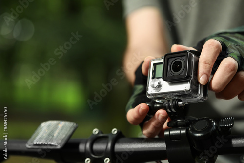 Man with modern action camera on bicycle outdoors, closeup