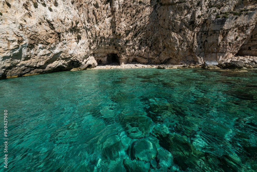 Scenic view of coastal rocky cliff and turquoise waters on a sunny day on Zakynthos Island in Greece Scenic view of coastal rocky cliff and turquoise waters on a sunny day on Zakynthos Island in Greece