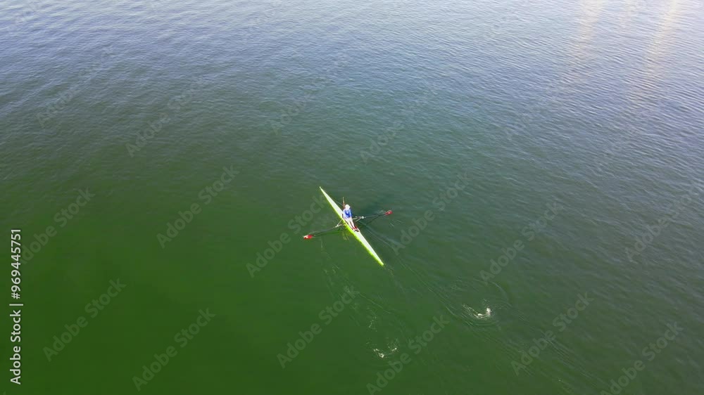 Aerial view of a solo rower exercising early in the morning on a body of water in Long Beach