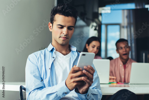 Male employee browsing banking application for making online money transfer during work day, Spanish administrator with cellphone gadget checking mail box during wireless corporate messaging