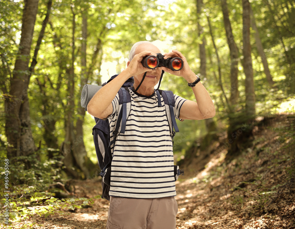 Mature male hiker looking through binoculars Mature male hiker looking through binoculars