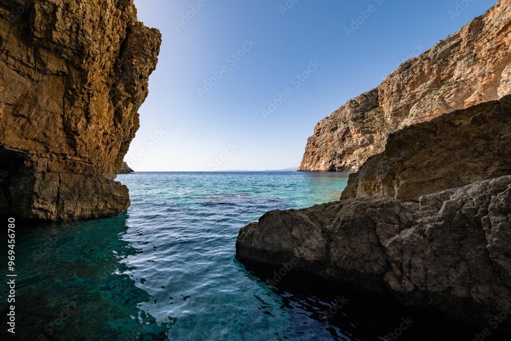Serene blue waters and majestic coastal cliffs against a clear blue sky in Zakynthos island, Greece Serene blue waters and majestic coastal cliffs against a clear blue sky in Zakynthos island, Greece