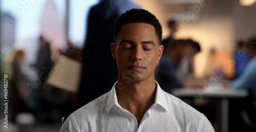 male employee meditating in office at work relaxing enjoying break, in the midst of the hustle and bustle and crowd, quietly praying for inner peace and the energy of zen and nirvana state, copy space