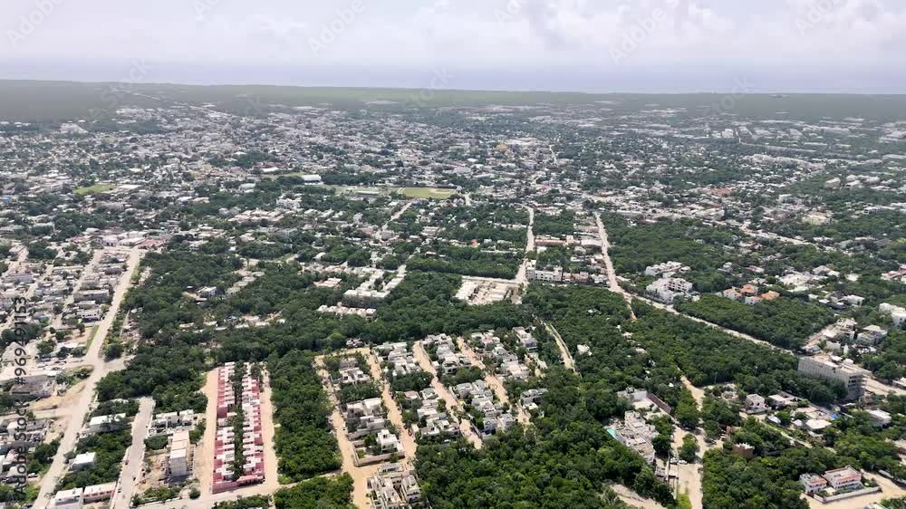 aerial drone view of downtown tulum with buildings and houses surrounded by green tropical areas and Caribbean Sea on the background on a cloudy morning in Mexico aerial drone view of downtown tulum with buildings and houses surrounded by green tropical areas and Caribbean Sea on the background on a cloudy morning in Mexico