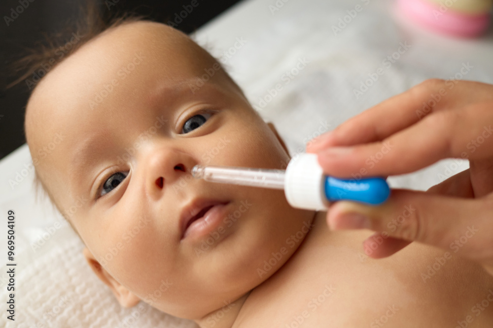 Unrecognizable doctor administering nasal spray to unwell newborn during medical checkup ensuring proper care for the infant battling flu symptoms indoors in hospital Unrecognizable doctor administering nasal spray to unwell newborn during medical checkup ensuring proper care for the infant battling flu symptoms indoors in hospital
