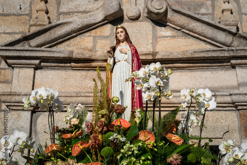 Imagem solene de Santa Barbara ornada num andor numa procissão de uma festa popular de verão photo