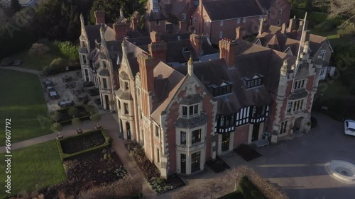 Close up aerial descending into a wide corner view of historical Wood Norton Hall near Worcester in England