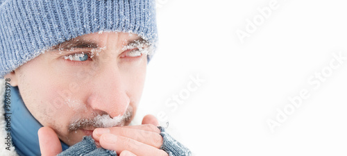 Handsome guy with blue eyes. Snowflakes on the face. Winter portrait. Copy space.