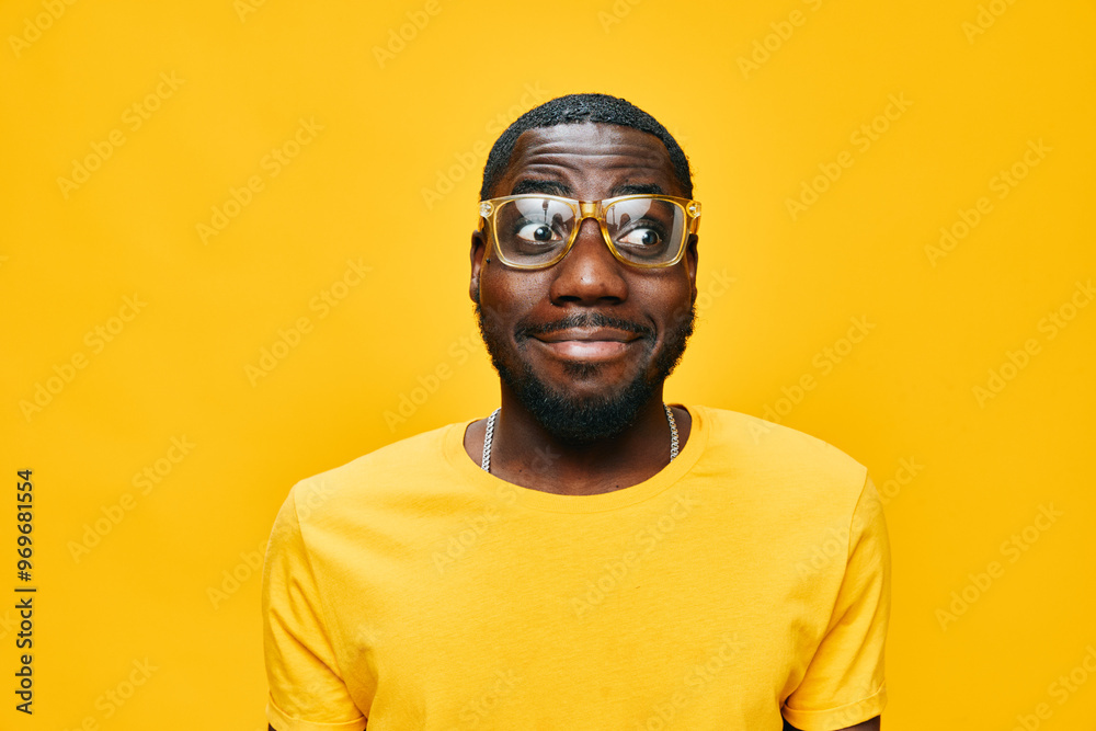 African man, wearing yellow shirt and glasses, with playful expression against a bright yellow background, showcasing confidence and joy Perfect for lifestyle and fashion concepts African man, wearing yellow shirt and glasses, with playful expression against a bright yellow background, showcasing confidence and joy Perfect for lifestyle and fashion concepts