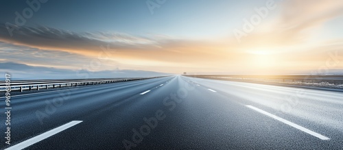 Empty highway leading to a foggy sunrise.