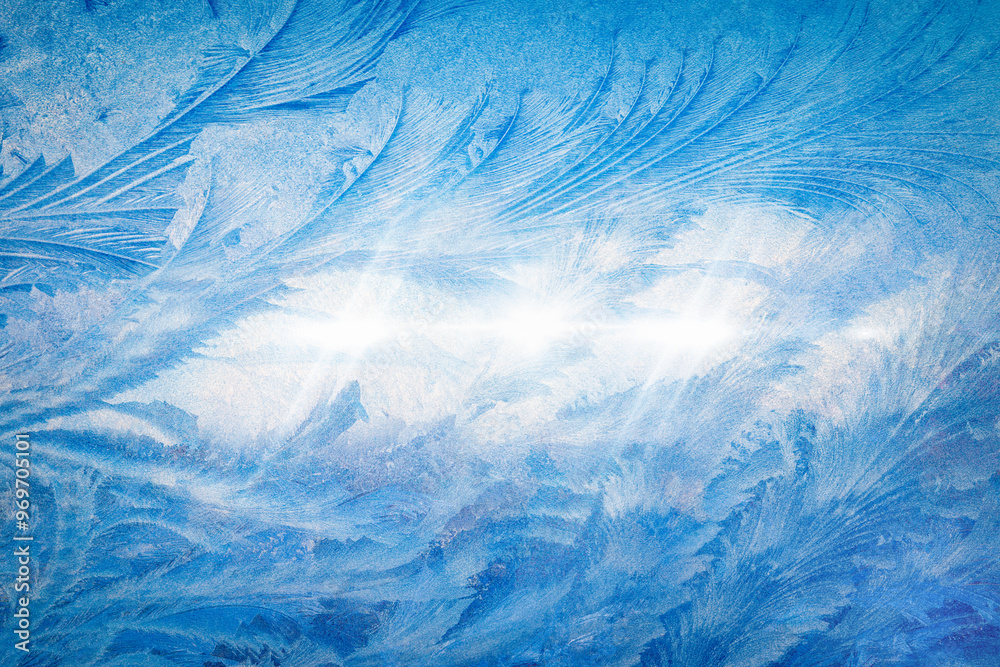 Frost patterns on frozen window create beautiful winter scene with intricate ice crystals illuminated by soft light. Cold weather forecast concept, blue seasonal winter background Frost patterns on frozen window create beautiful winter scene with intricate ice crystals illuminated by soft light. Cold weather forecast concept, blue seasonal winter background