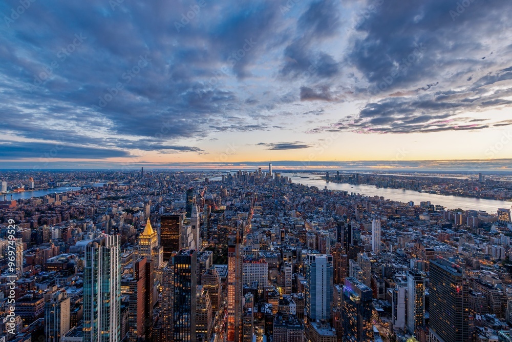 Fototapeta premium Aerial view of New York City skyline at sunset with dramatic clouds and the Hudson River