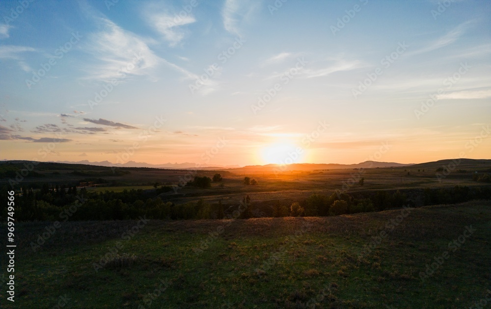 Beautiful sunset over a vast, green landscape with a clear sky. Alberta, Canada Beautiful sunset over a vast, green landscape with a clear sky. Alberta, Canada