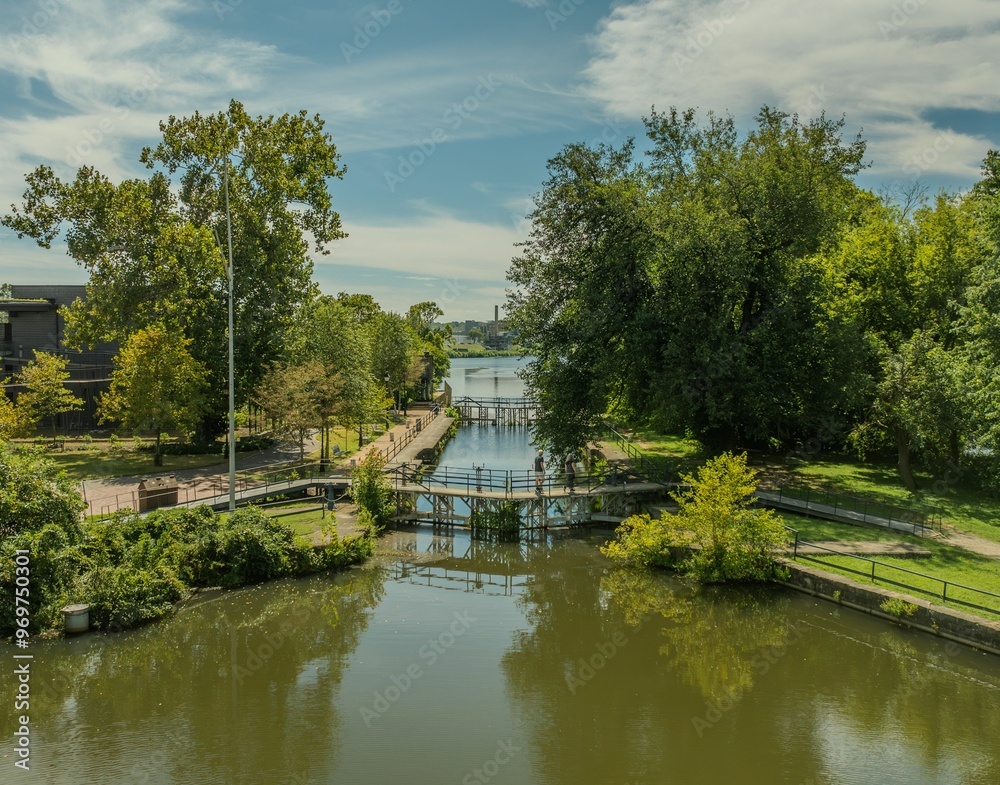 Serene park with waterway and lush green trees Serene park with waterway and lush green trees
