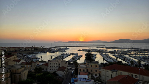 sunset over the port of Alghero photographed from the rooftop of a hotel

