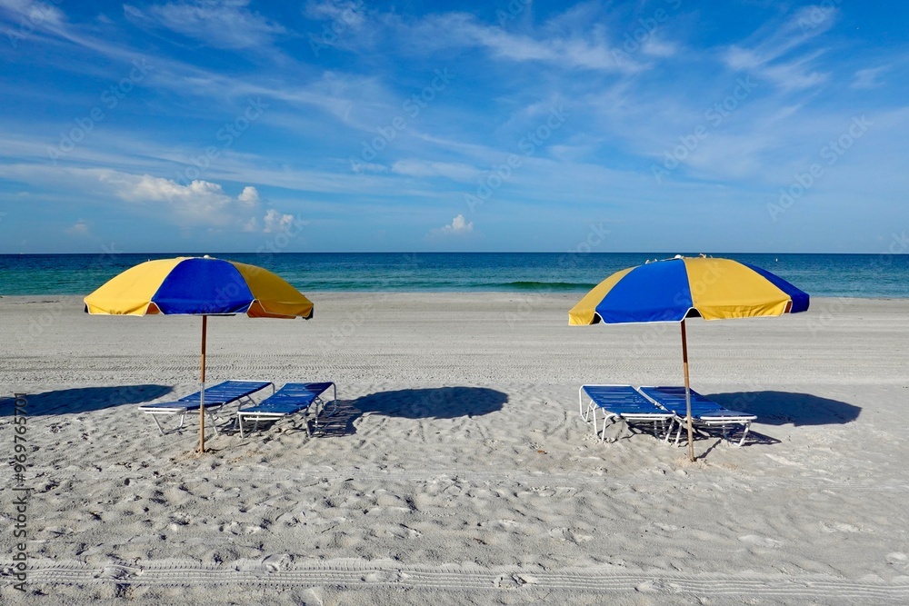Blue and yellow beach umbrellas in the sand on a beach. Blue and yellow beach umbrellas in the sand on a beach.