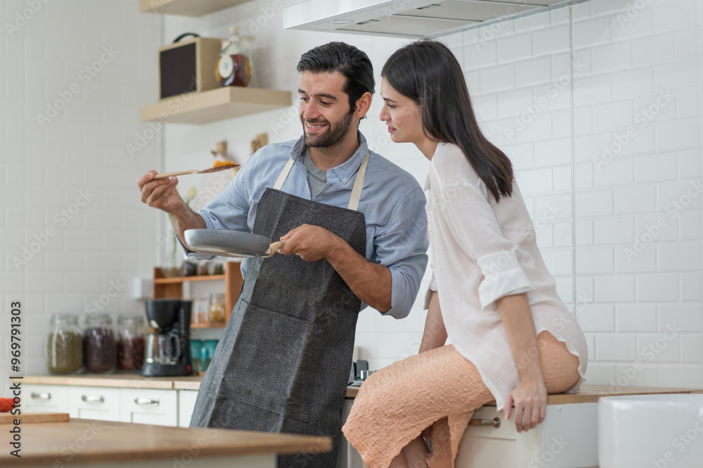Happy young couple cooking together in the kitchen at home Happy young couple cooking together in the kitchen at home