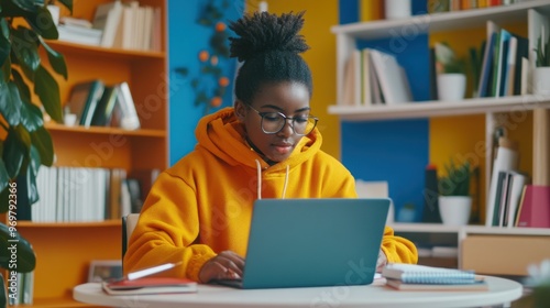 A dedicated student participating in a virtual class through a laptop surrounded by notebooks and stationery in a bright, modern study environment photo