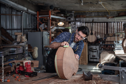 Luthier creating a guitar and using tools in a traditional photo